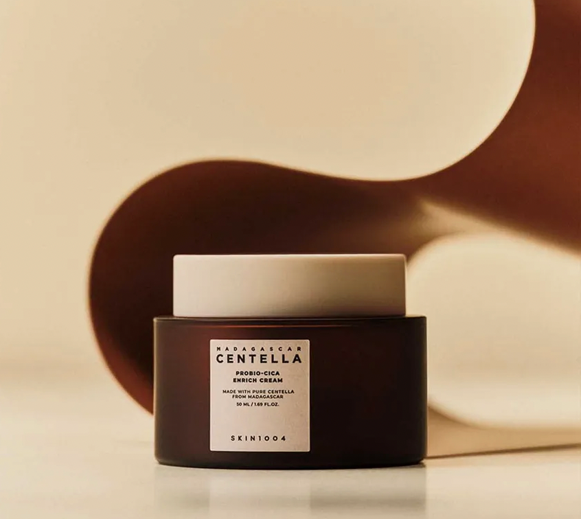 Skincare product with a black container and white lid on a beige background