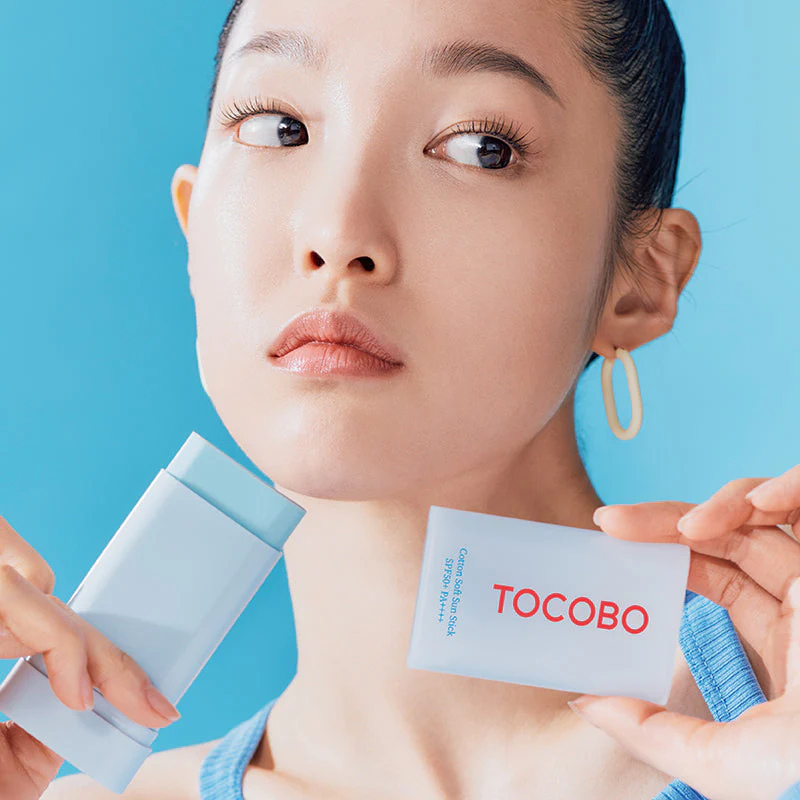 Woman holding a Tocobo product against a blue background