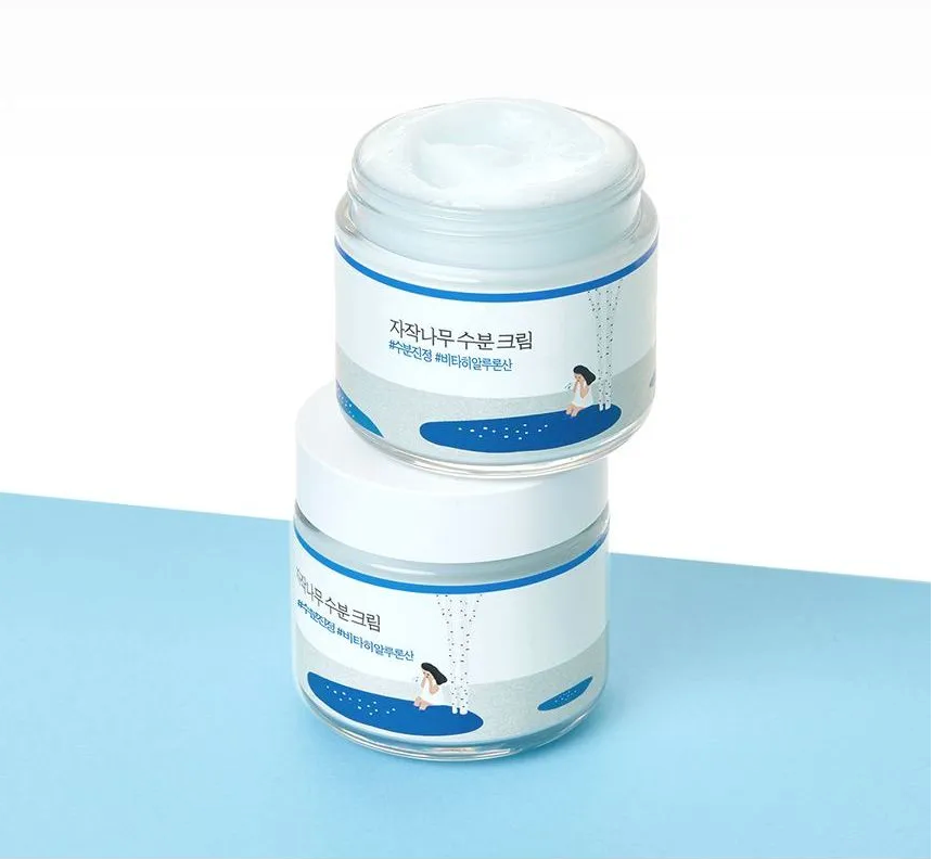 Two jars of cream with Korean text on a light blue background