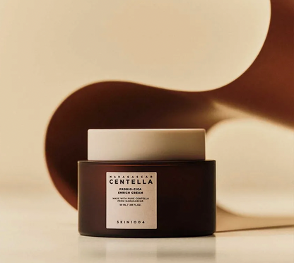 Skincare product with a black container and white lid on a beige background