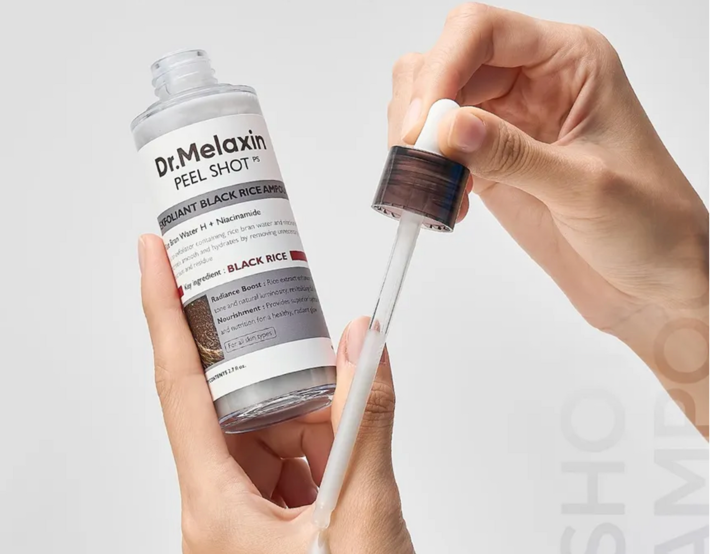 Dr. Melaxin peel shot bottle with dropper held by a hand against a light gray background
