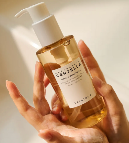 Bottle of Mad Cow Centella Light Cleansing Oil held in a hand with a neutral background