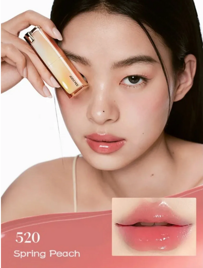 Woman holding a cosmetic product with a close-up of a lip color swatch labeled 'Spring Peach'.