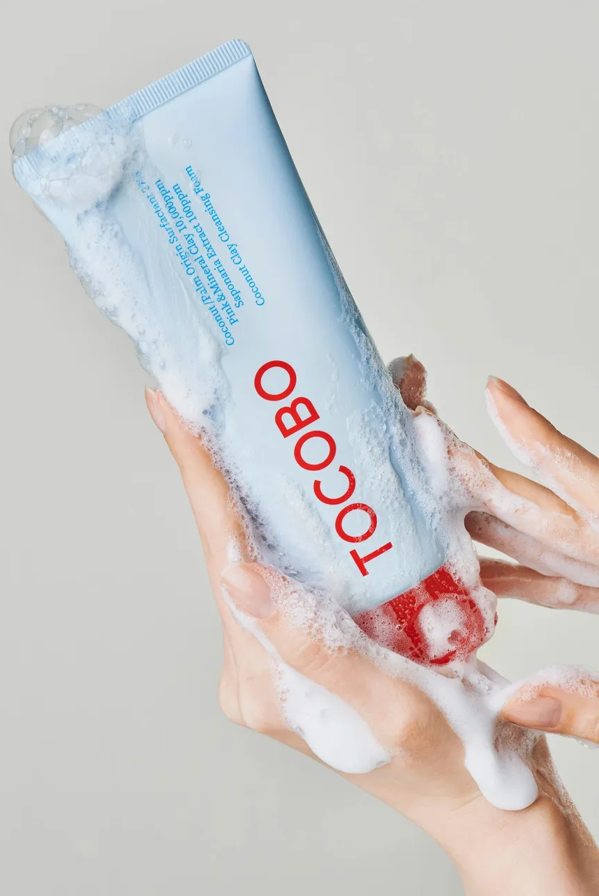 Tocobo skincare product being applied to a hand with a light gray background