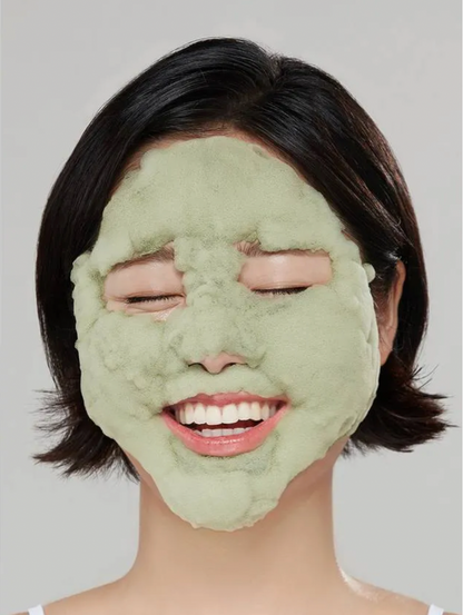 Person wearing a green face mask against a plain background