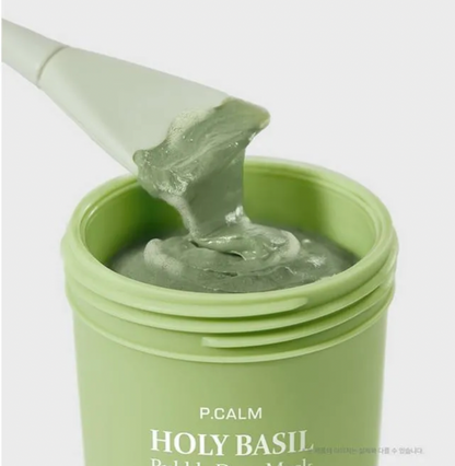 Green jar of P.CALM Holy Basil product with a spatula on a white background