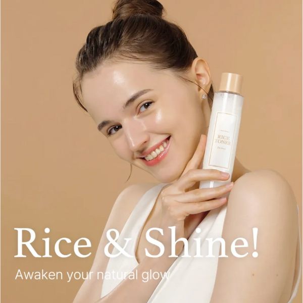 Woman holding a bottle labeled 'Rice & Shine' against a beige background
