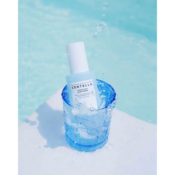 Skincare bottle with blue liquid in a glass container on a light blue background